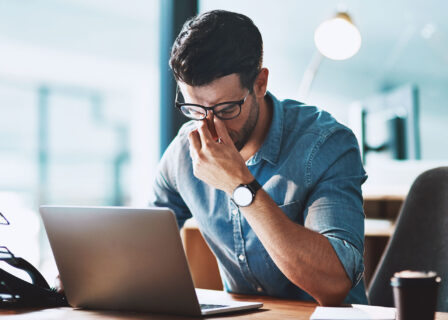 Zmęczony mężczyzna przed laptopem
